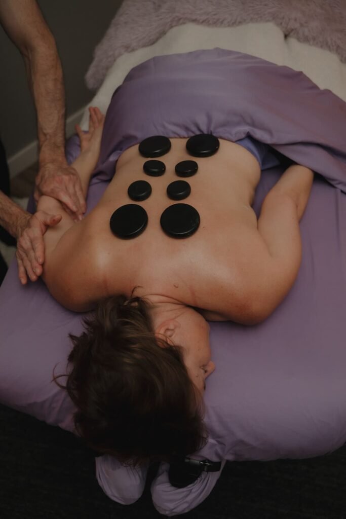 Black basalt stones placed along a client's back during a hot stone massage