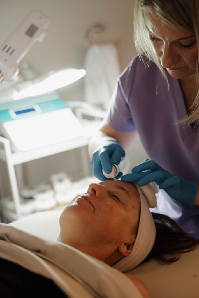 Esthetician performing a skin treatment on a client in the treatment room