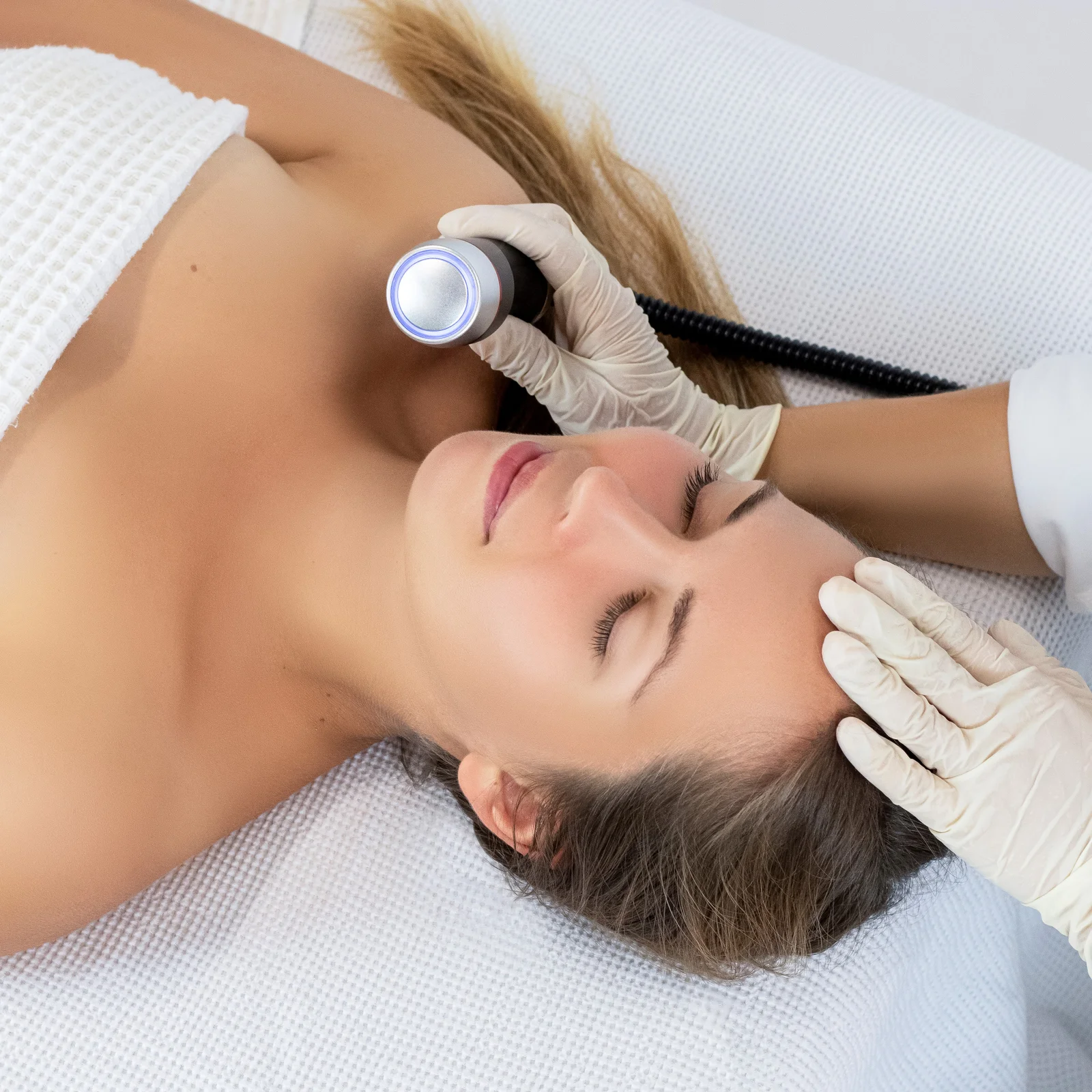 Woman relaxing during a radiofrequency facial with a handheld device