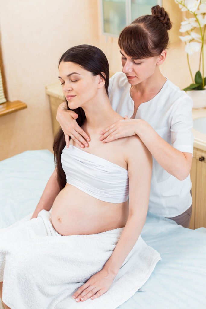Pregnant woman receiving a gentle shoulder massage