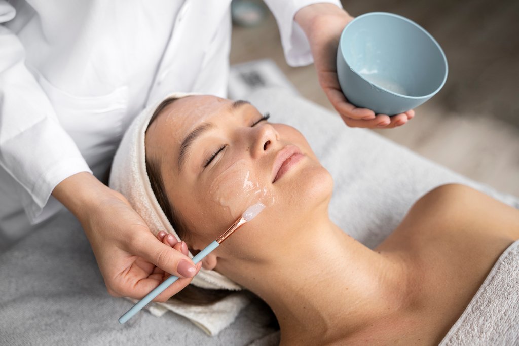 Woman receiving a professional chemical peel applied with a brush